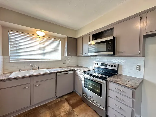 a kitchen with stainless steel appliances granite countertop a sink and a stove
