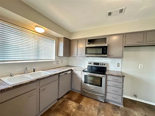 a kitchen with a sink stove and microwave
