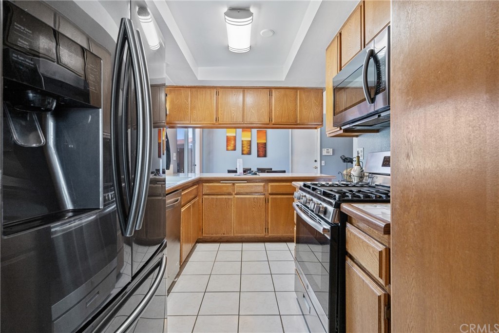 782 De La Luz Circle Perris, CA 92571 - Photo 13 of 25 a kitchen with stainless steel appliances granite countertop a stove a sink and a refrigerator