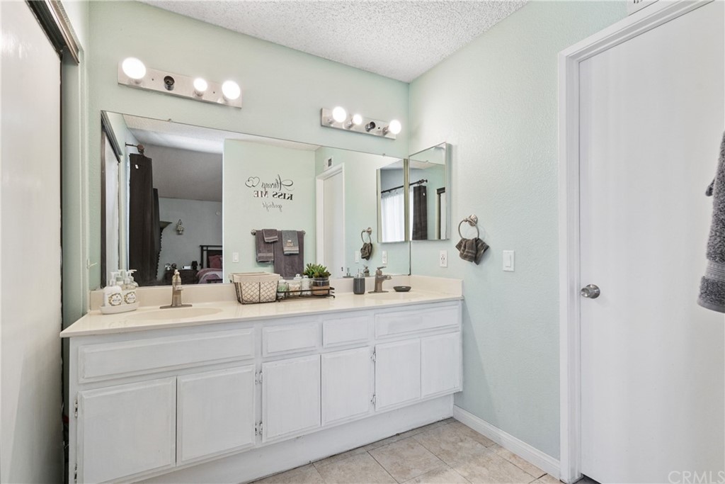 782 De La Luz Circle Perris, CA 92571 - Photo 17 of 25 a bathroom with a double vanity sink and a mirror