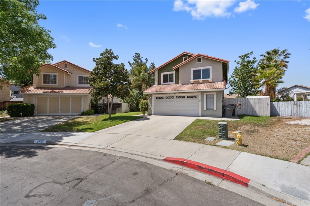 782 De La Luz Circle Perris, CA 92571 - Photo 2 of 25 a front view of a house with a yard and garage