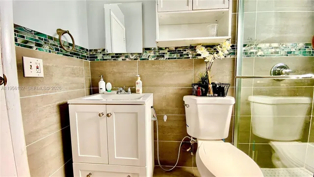 a bathroom with a toilet a sink and mirror