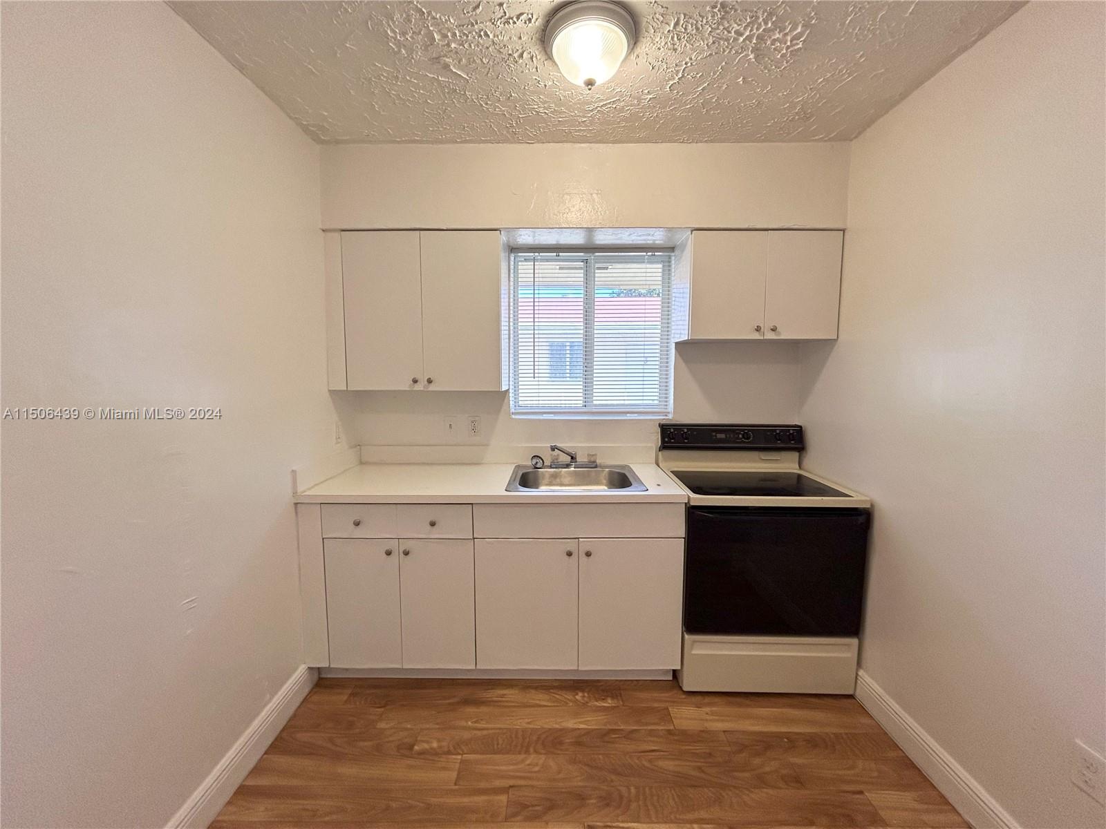 641 Northeast 86th Street, Unit 3 Miami, FL 33138 - Photo 2 of 10 a view of cabinets with wooden floor