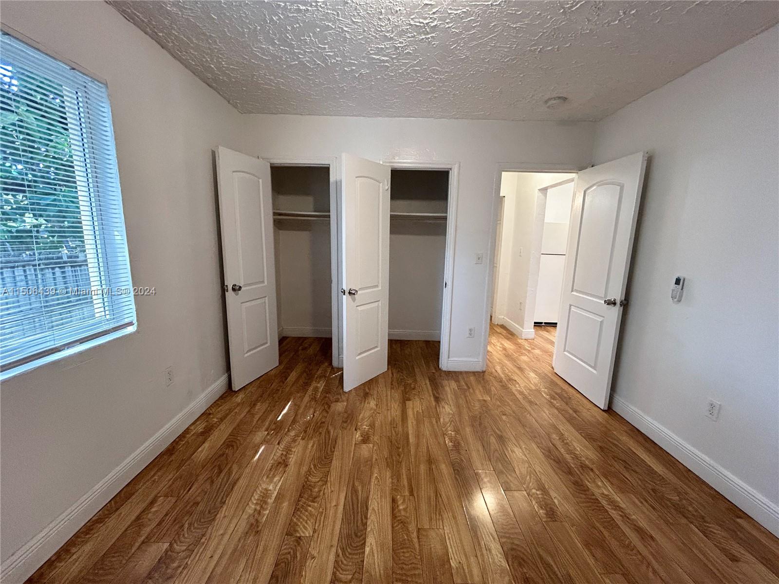 641 Northeast 86th Street, Unit 3 Miami, FL 33138 - Photo 7 of 10 a view of a room with wooden floor and window