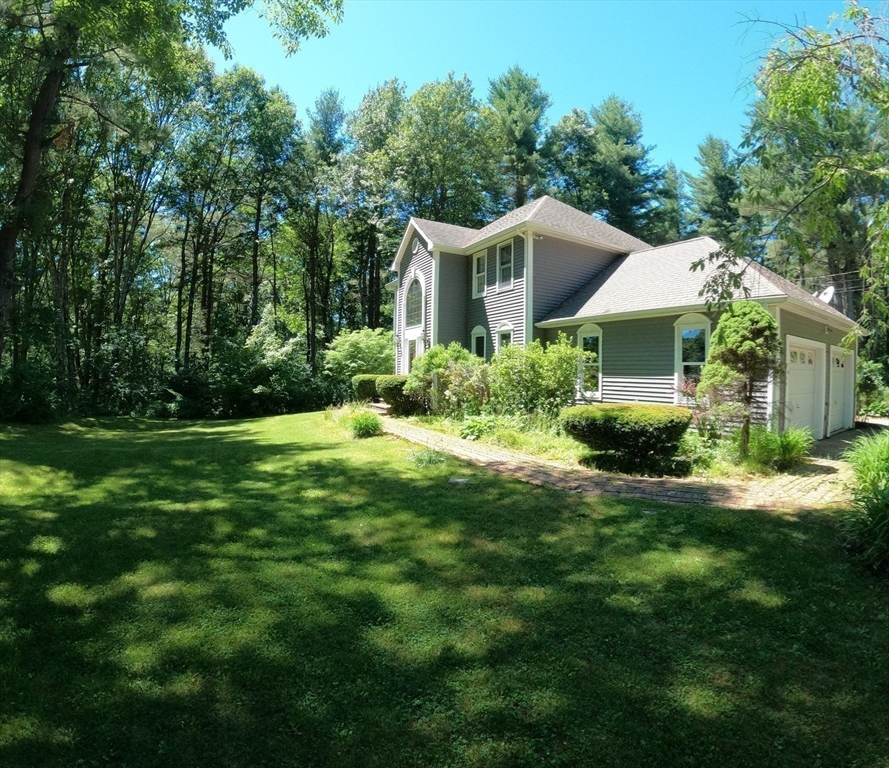 a aerial view of a house with yard and green space