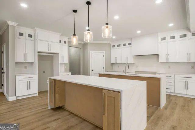 a kitchen with kitchen island white cabinets and refrigerator