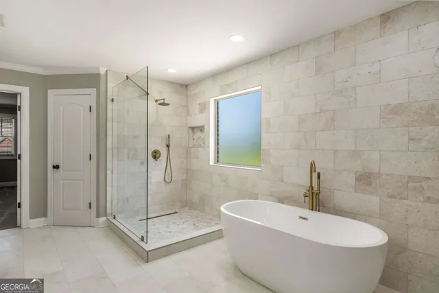 a bathroom with a white bath tub a shower and a sink