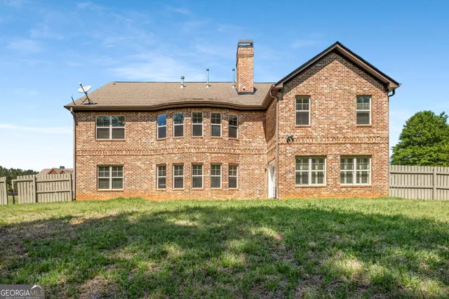a view of a house with a big yard and large trees