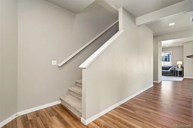 a view of a hallway view with wooden floor and staircase