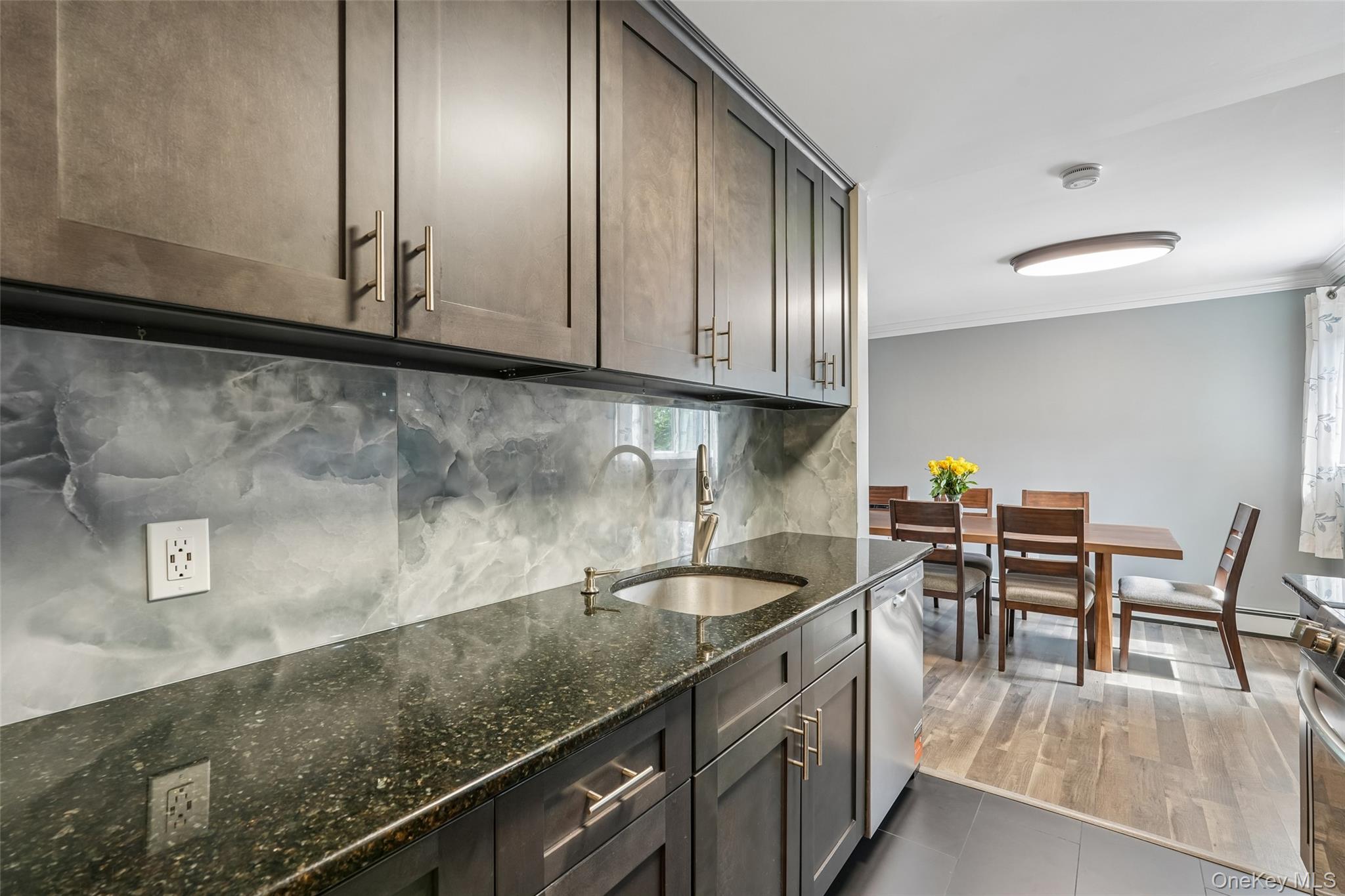 2 Secora Road, Unit C5 Monsey, NY 10952 - Photo 14 of 32 Kitchen featuring dark wood-finish cabinetry, a dark speckled countertop, and a stainless steel undermount sink