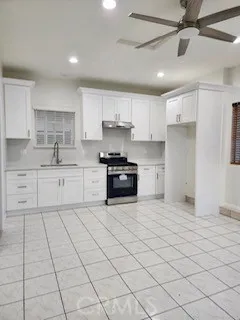 a kitchen with granite countertop a sink window and cabinets