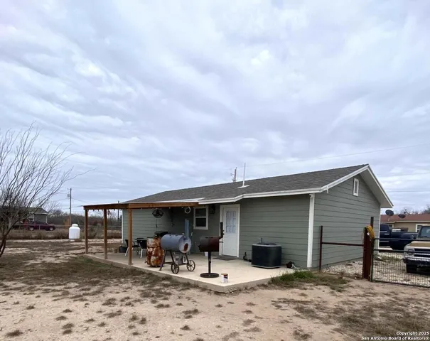 a view of a house with a yard and a patio