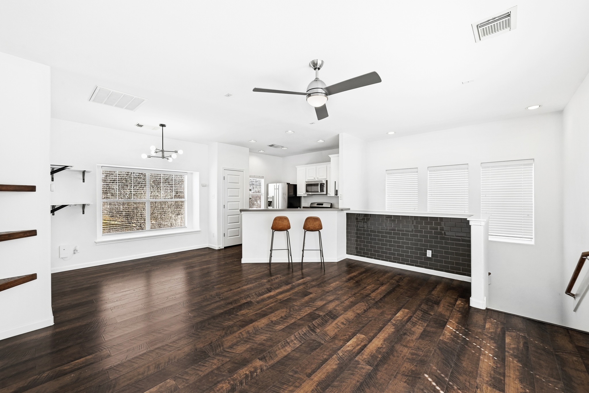 2821 Saville Loop, Unit 21C Austin, TX 78741 - Photo 12 of 31 A custom tile accent wall serves as a focal point in the living room, adding a textured, modern touch to the neutral-toned walls