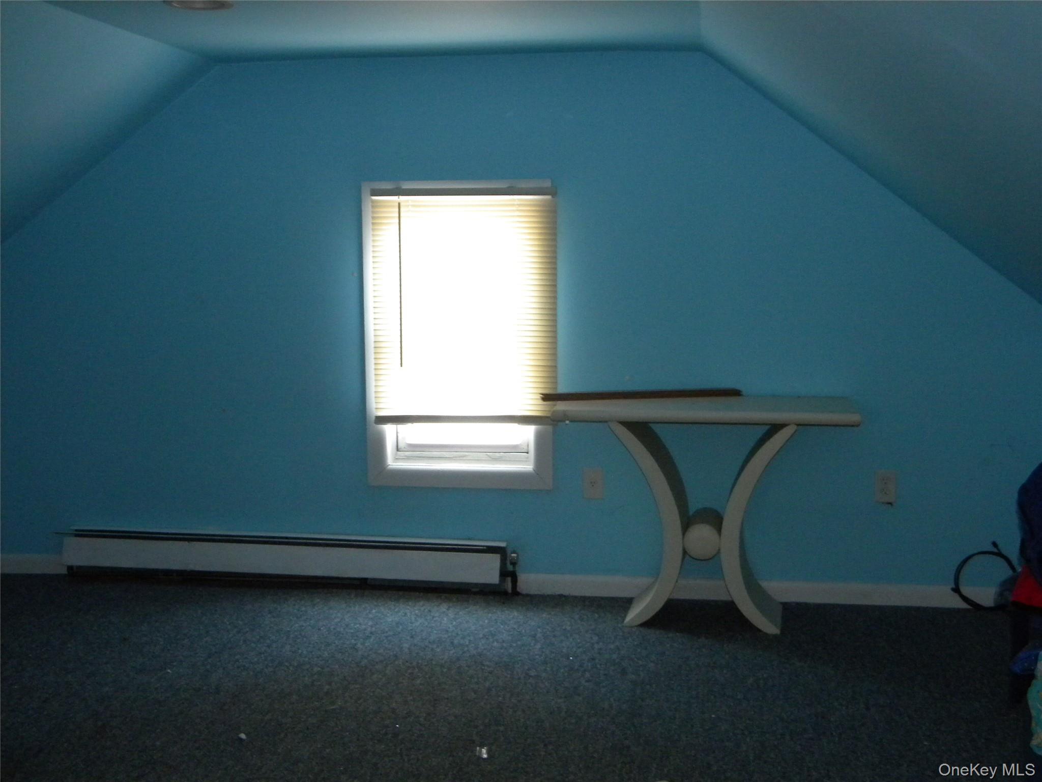 241-26 86th Road Queens, NY 11426 - Photo 23 of 38 a room with a chair and a window