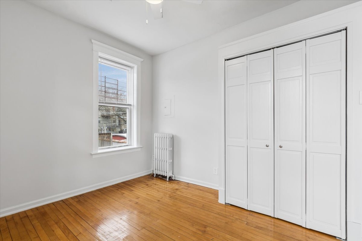 5414 North Broadway, Unit 2 Chicago, IL 60640 - Photo 13 of 18 an empty room with wooden floor closet and windows