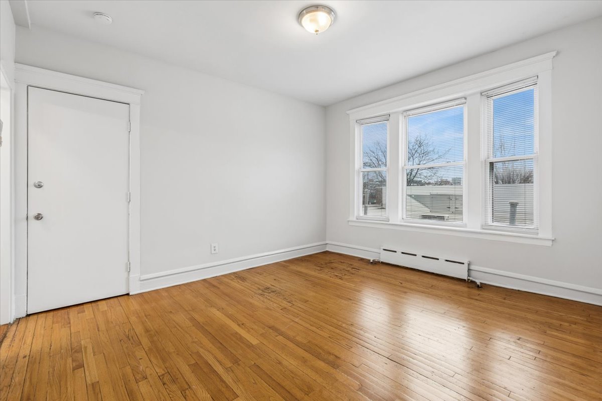 5414 North Broadway, Unit 2 Chicago, IL 60640 - Photo 3 of 18 a view of an empty room with wooden floor and a window