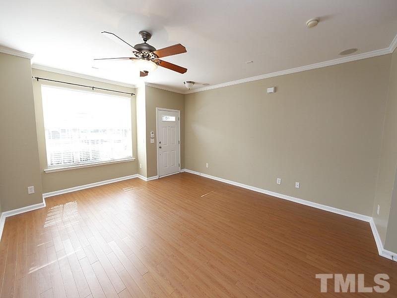 8341 City Loft Court Raleigh, NC 27613 - Photo 3 of 19 an empty room with wooden floor fan and windows