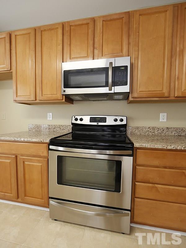 8341 City Loft Court Raleigh, NC 27613 - Photo 9 of 19 a kitchen with stainless steel appliances granite countertop a stove microwave and cabinets