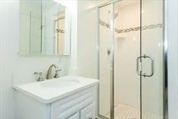 a bathroom with a sink shower and a mirror