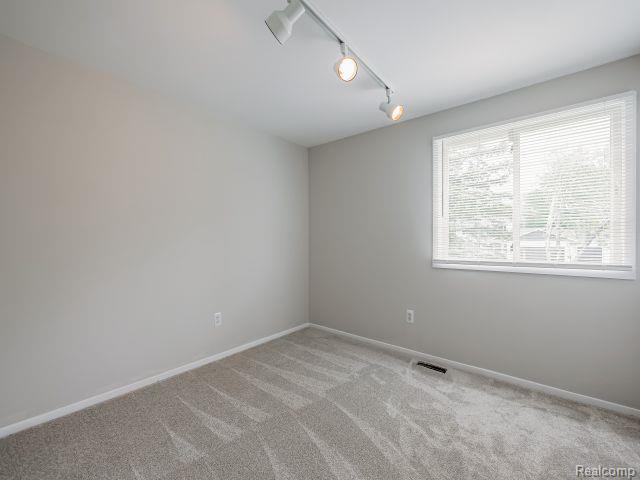 21728 Ruth Street Farmington, MI 48336 - Photo 33 of 54 Interior room with light gray walls, track lighting, and a window with blinds