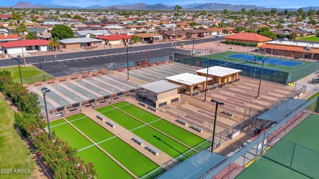 an aerial view of a tennis ground with a mountain