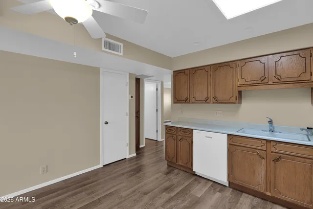 a kitchen with granite countertop a sink cabinets and wooden floor