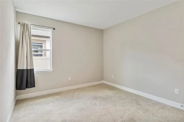 an empty room with a window and a ceiling fan