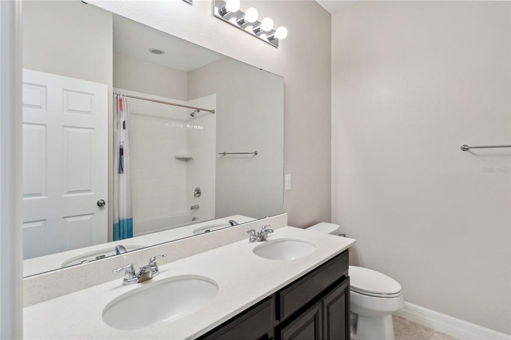 2066 Cresswell Street Ocoee, FL 34761 - Photo 19 of 32 a bathroom with a double vanity sink toilet and a mirror