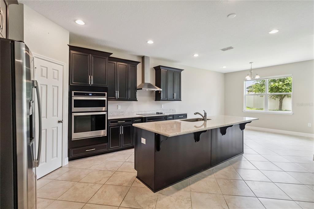 2066 Cresswell Street Ocoee, FL 34761 - Photo 8 of 32 a kitchen with stainless steel appliances granite countertop a refrigerator and a sink