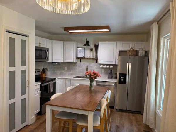 a kitchen with a sink a microwave a refrigerator and cabinets