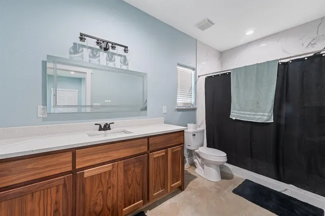 a bathroom with a sink toilet and mirror