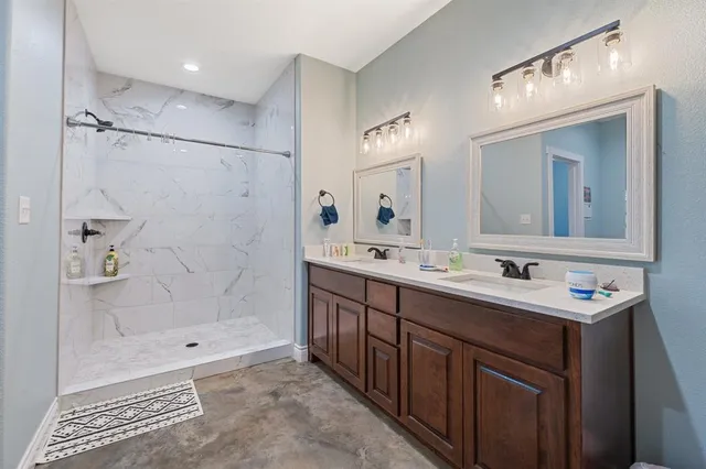 a bathroom with a sink a toilet a mirror and shower