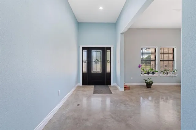 an empty room with floor to ceiling window and ceiling fan