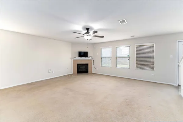 an empty room with windows and ceiling fan