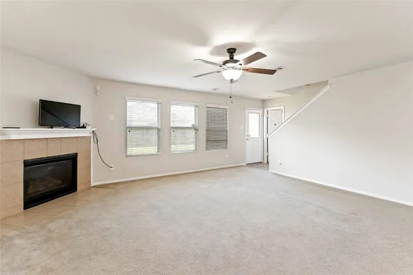 a view of an empty room with a fireplace and a window