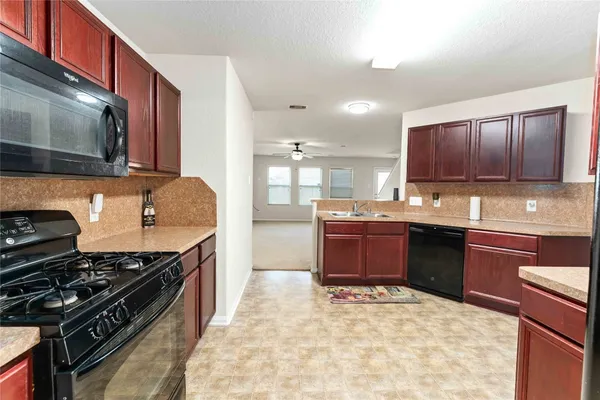 a kitchen with stainless steel appliances granite countertop a stove a sink and a microwave