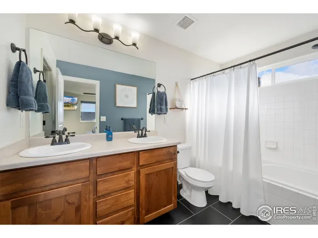 a bathroom with a sink a toilet a mirror a lamp and vanity