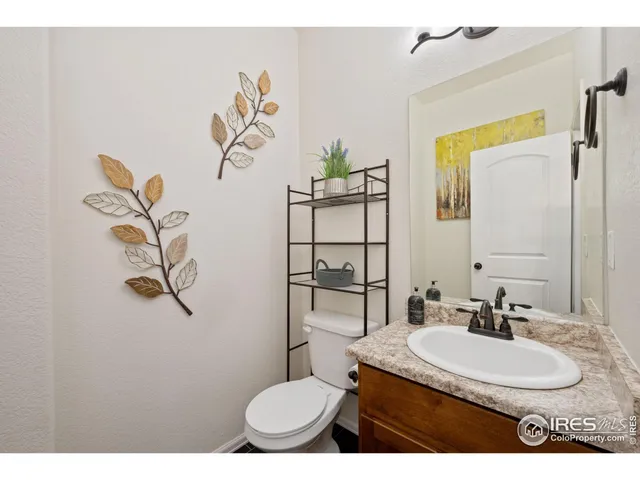 a bathroom with a granite countertop sink a toilet and a mirror