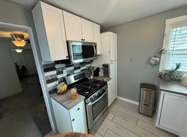 a kitchen with stainless steel appliances a stove a microwave a refrigerator and cabinets