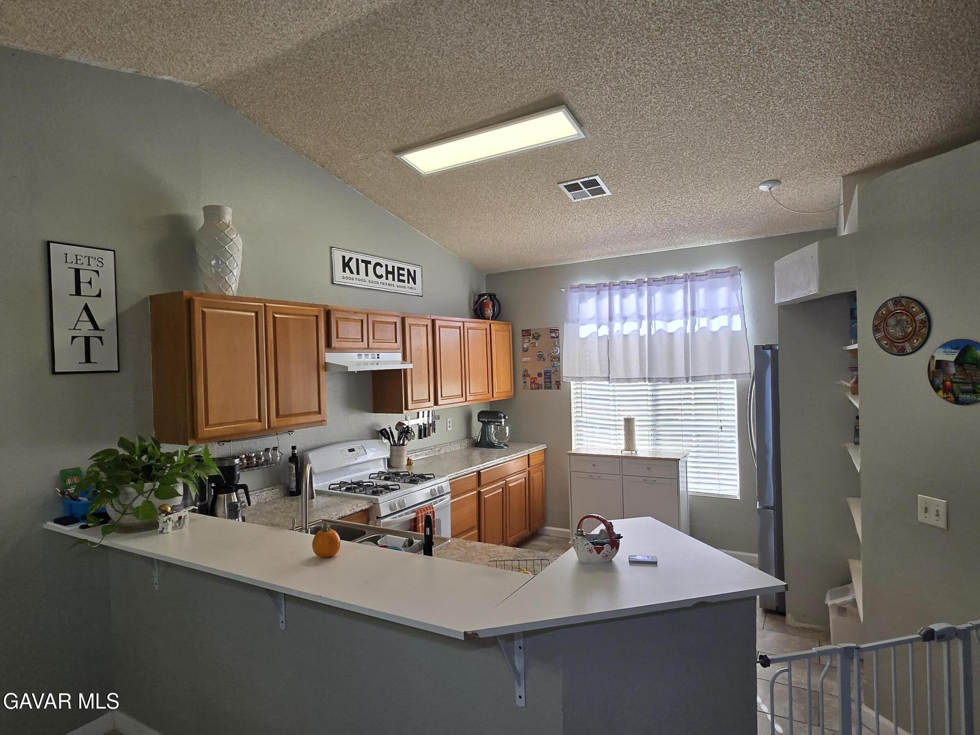 3840 Hatcher Place Rosamond, CA 93560 - Photo 12 of 28 a kitchen with a sink stove and refrigerator