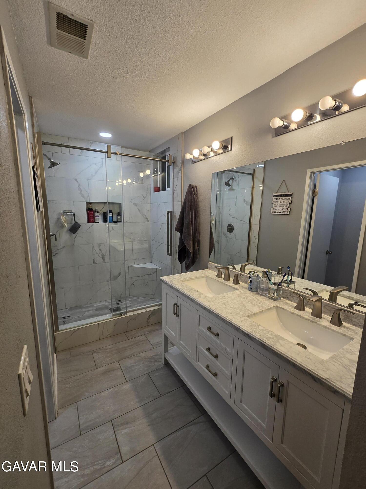 3840 Hatcher Place Rosamond, CA 93560 - Photo 8 of 28 a bathroom with a granite countertop sink mirror and shower