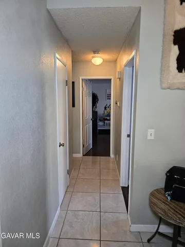 a view of a hallway with wooden shelves