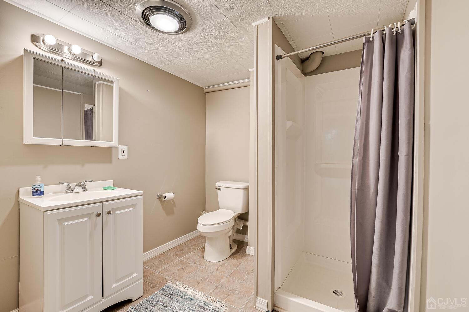 238 Suttons Lane Edison, NJ 08817 - Photo 18 of 21 a bathroom with a toilet a sink and shower