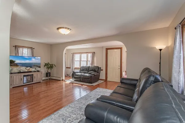 a kitchen with stainless steel appliances granite countertop a stove a refrigerator a sink a dining table and chairs