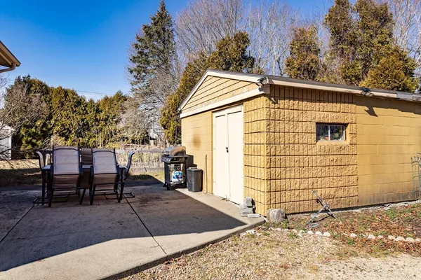 a view of a patio with table and chairs with wooden fence and plants