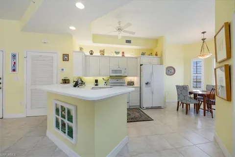 a kitchen with kitchen island a sink counter and chairs
