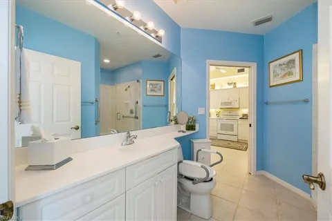 a en suite bathroom with a double vanity sink a mirror and shower
