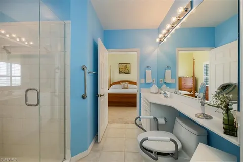 a view of a livingroom with a chandelier fan and windows