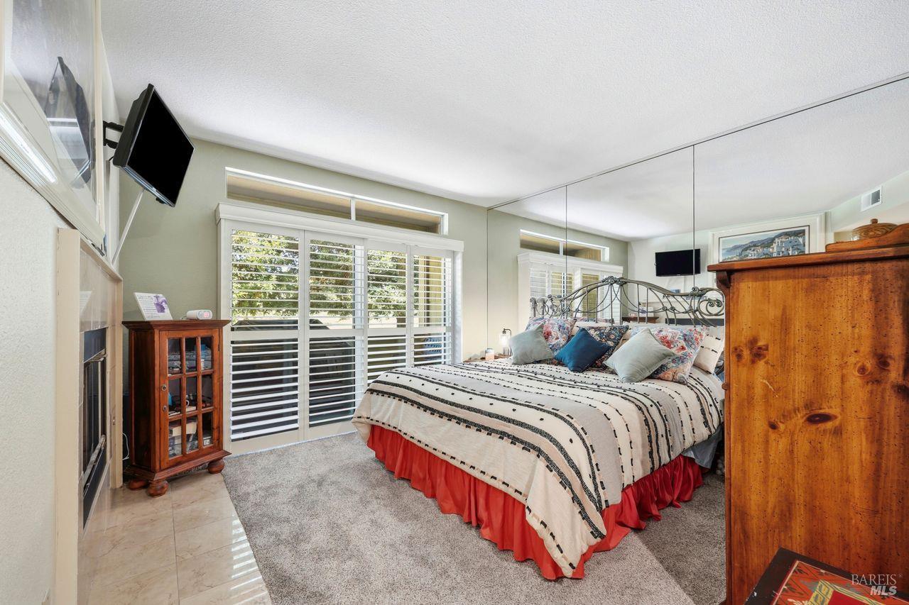 2092 Stonefield Lane Santa Rosa, CA 95403 - Photo 23 of 44 a bedroom with a bed a flat screen tv and guitar