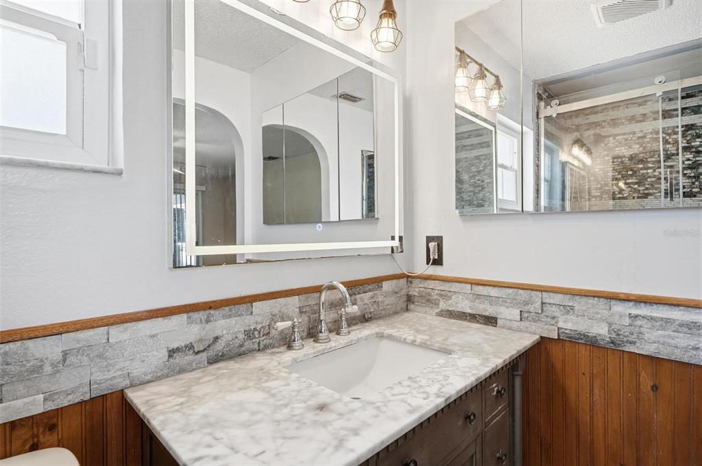 1071 Angora Street Deltona, FL 32725 - Photo 13 of 45 a bathroom with a granite countertop sink and a mirror